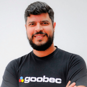 Foto do Daniel Santos,Gerente de Conhecimento e Desenvolvimento Goobec. Daniel veste um blusa preta, escrito Goobec. Ele tem pelo clara e tem barba. 